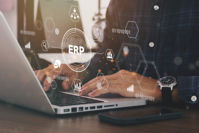 Profissional usando notebook com interface digital de ERP em nuvem, representando integração de dados e automação na gestão empresarial.