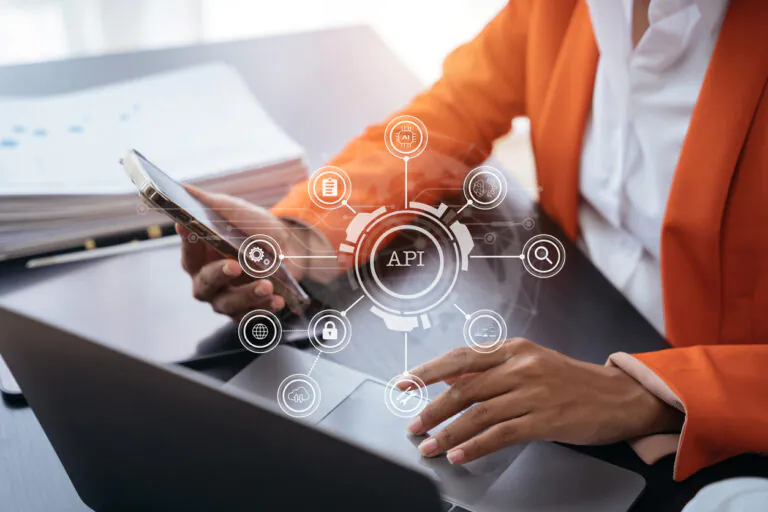 Imagem de uma pessoa usando um smartphone com uma interface gráfica de API para integração de ERP via API, representando tecnologia e inovação empresarial.