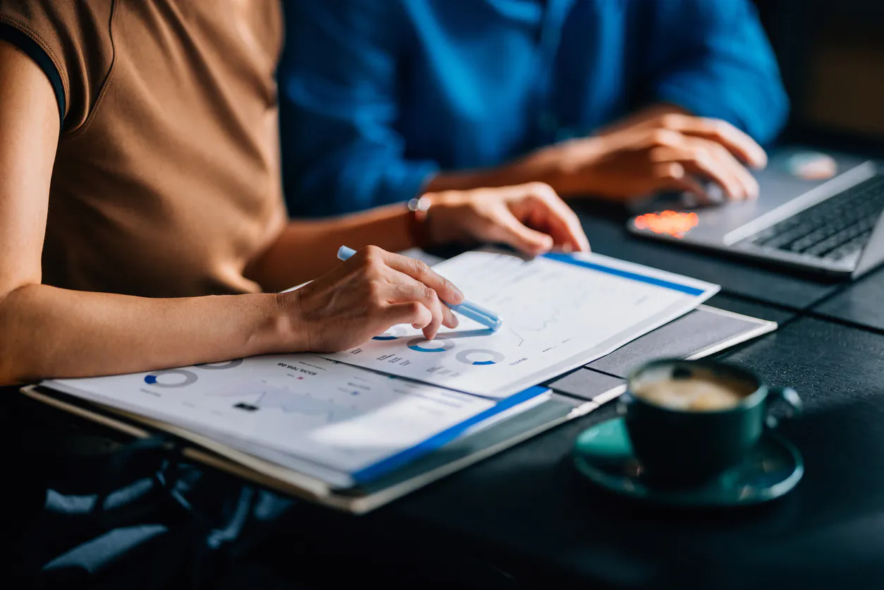 Equipe de profissionais analisando gráficos e relatórios financeiros no contexto de gestão financeira para empresas de serviços.