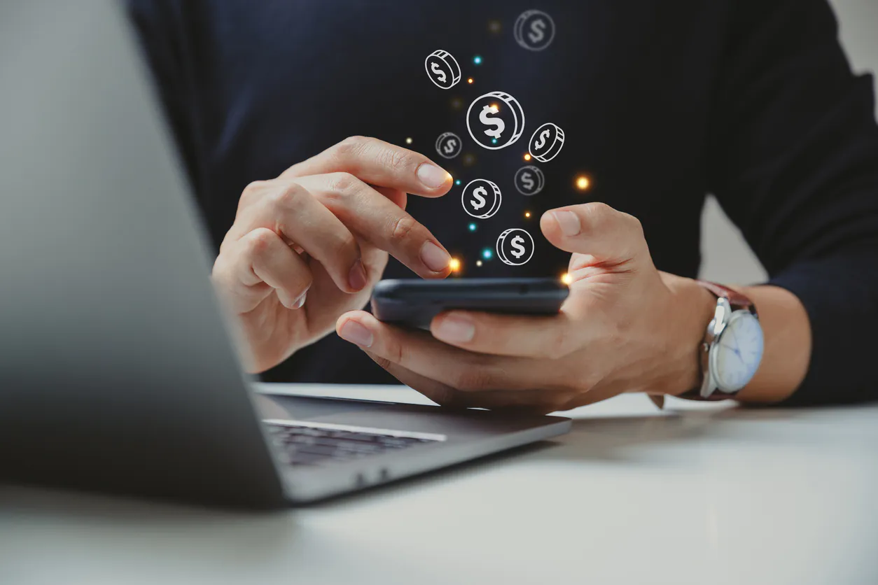 Pessoa utilizando smartphone para realizar transferências de dinheiro e comparando softwares financeiros de PIX em massa