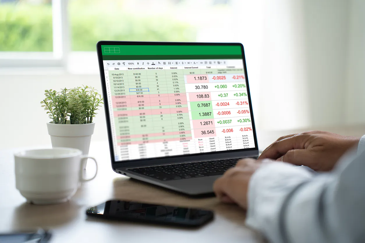 Pessoa analisando dados financeiros em software especializado comparado a planilha Excel em ambiente de escritório