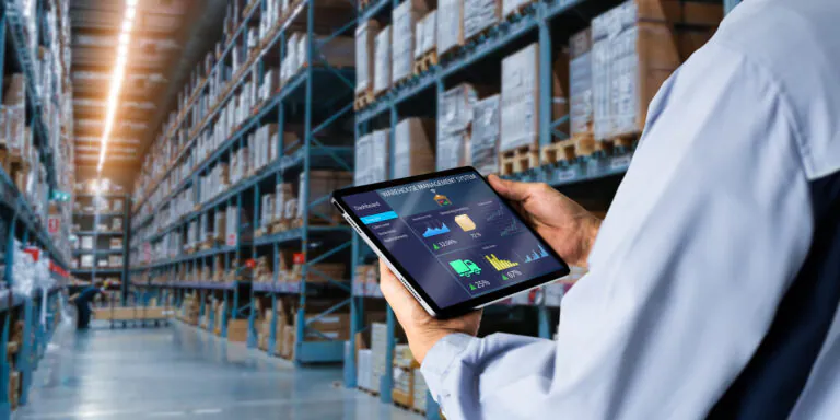 Trabalhador em centro de distribuição/depósito de logística usando um tablet com interface digital de controle de estoque e gestão de armazém entre prateleiras
