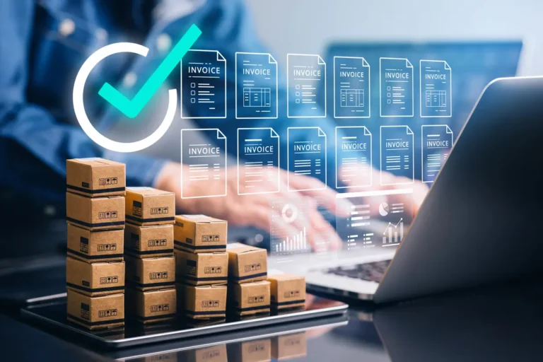 Melhores sistemas de contas a pagar: caixas de encomendas sobre uma mesa enquanto um profissional usa um notebook com interface de faturas (invoices) e indicadores digitais de conferência e aprovação.