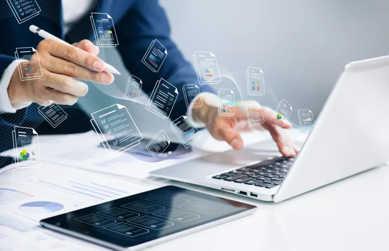 Melhores sistemas de contas a receber: Pessoa analisando dados em um notebook enquanto interface digital com documentos e gráficos flutua na tela, representando tecnologia para gestão financeira e contas a receber.