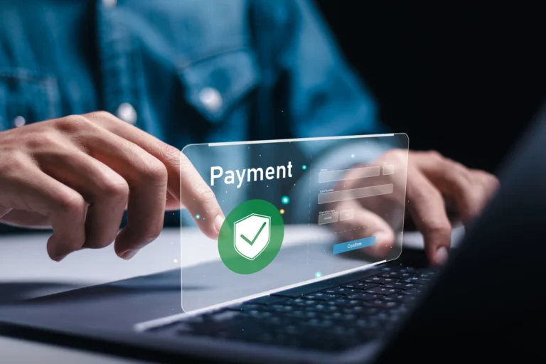 Mãos operando um notebook com interface de pagamento em destaque, mostrando verificação de aprovação e telas de confirmação, com proteção por ícone de escudo. Melhores softwares de aprovação de pagamentos