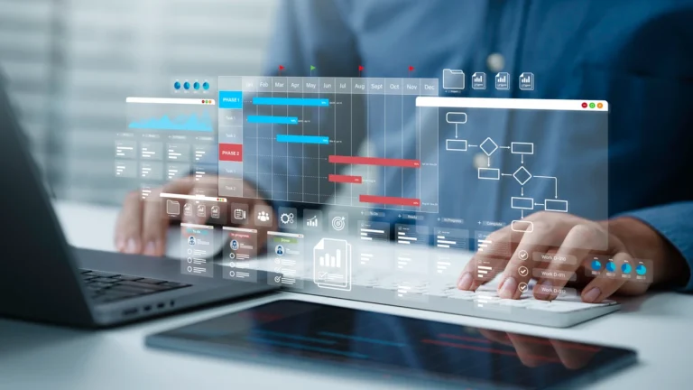 Melhores softwares de fluxo de caixa: pessoa usando notebook com painel de dashboard e gráficos financeiros em múltiplas telas sobrepostas, em ambiente corporativo.
